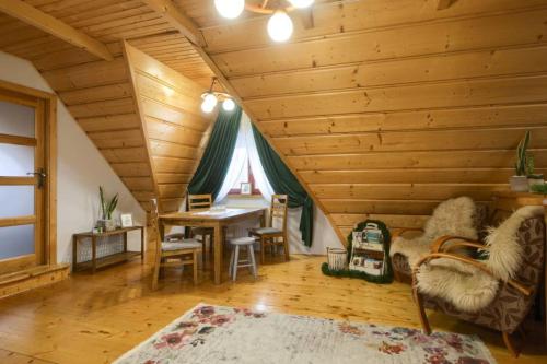 a living room with a wooden ceiling with a table and chairs at Rodzinny Dom Wypoczynkowy u Ciwersa in Białka Tatrzańska