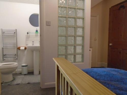 a bathroom with a sink and a toilet and a stairway at Flat, amazing balcony sea view, bike store, with sun deck in Margate