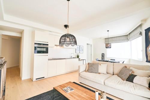 a living room with a couch and a kitchen at Diamant 1BR in Brussels