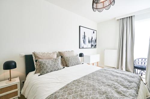 a bedroom with a large white bed with pillows at Diamant 1BR in Brussels