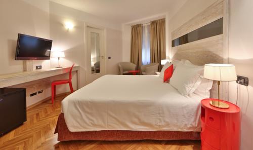a hotel room with a large bed and a television at Hotel Alla Posta in Saint Vincent