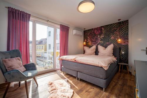 a bedroom with a bed and a chair and a window at Ferienhaus Inselliebe in Malchow