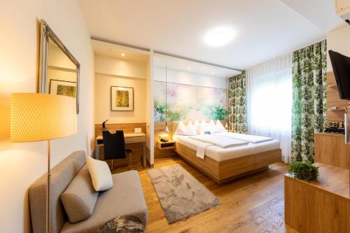 a bedroom with a bed and a living room at Hotel Süd Graz in Graz