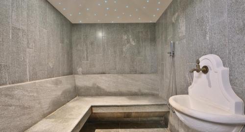 a bathroom with a tub and a sink and a toilet at Hotel Alla Posta in Saint Vincent