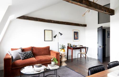 een woonkamer met een bank en een tafel bij Cosy Loft Apartment - minutes from Angel Tube St. in Londen