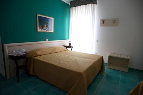 1 dormitorio con cama y pared verde en L'Ulivo Sul Mare, en Cetraro