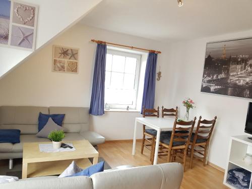 ein Wohnzimmer mit einem Sofa und einem Tisch in der Unterkunft Ferienhaus Poseidon in Neuharlingersiel