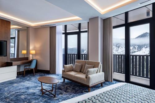 a hotel room with a bed and a desk and a chair at Ambassadori Goderdzi Hotel in Goderdzi