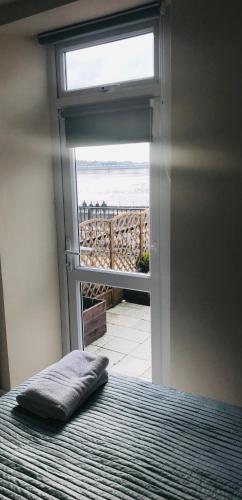a bed with a pillow in a room with a window at Pavilion Holiday Apartments in Weston-super-Mare