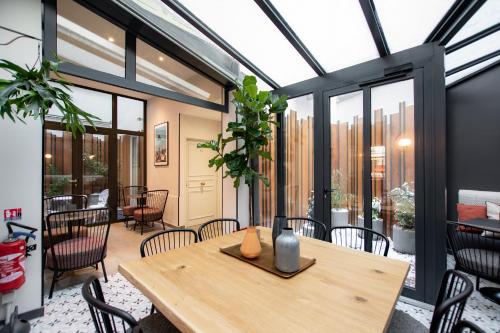 a dining room with a table and chairs at Hôtel de L'Esperance in Paris