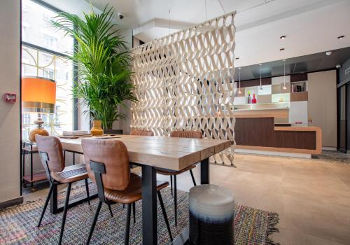 a dining room with a wooden table and chairs at Hôtel de L'Esperance in Paris