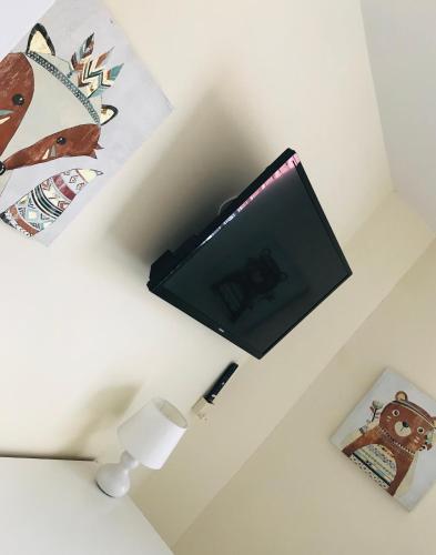 a tv on a wall in a room with a lamp at Pavilion Holiday Apartments in Weston-super-Mare