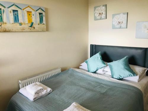 a bedroom with a bed with blue pillows at Pavilion Holiday Apartments in Weston-super-Mare