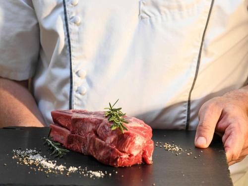 a man standing next to a piece of meat on a counter at Novotel Nice Arenas Aeroport in Nice