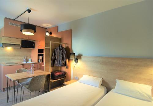 Habitación con cama, mesa y cocina. en Apparthotel Torcy, en Torcy