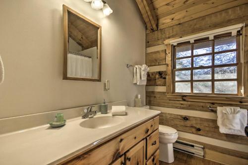 a bathroom with a sink and a toilet and a mirror at Riversong Cabin with Fire Pit on North River in Slanesville