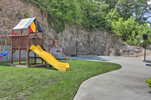a playground with a slide in the grass at The Lake Escape with Balcony and Pool Access! in Camdenton