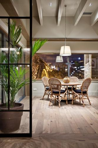 a dining room with a table and chairs and a potted plant at Vincci Ponte de Ferro in Vila Nova de Gaia