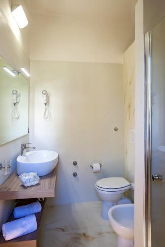 a white bathroom with a toilet and a sink at Michelangelo Cesenatico in Cesenatico