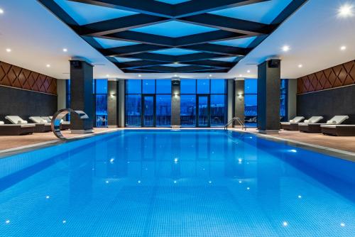 
a large swimming pool in a large room at Ambassadori Goderdzi Hotel in Khulo
