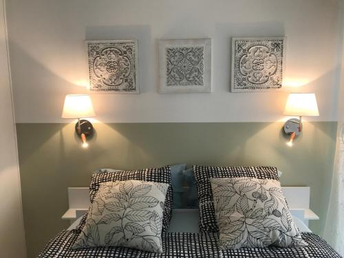 a bedroom with a bed with two lamps and two pillows at app Le Rocazur avec piscine et parking en bord de mer à 500M du centre ville in Menton