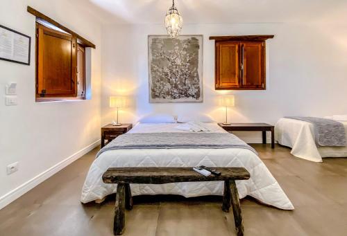 a bedroom with a bed with a bench in it at Tenuta Novecento Bioagriturismo in Agerola
