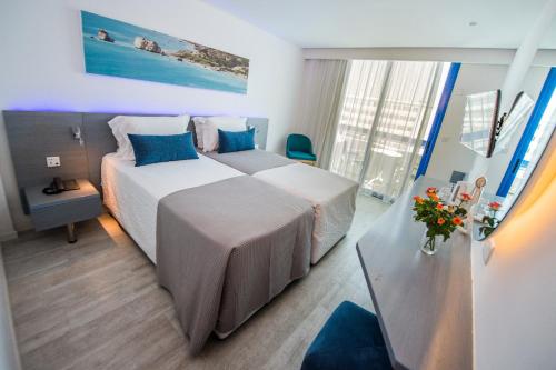 a hotel room with two beds and a table at Anonymous Beach Hotel (Adults 16+) in Ayia Napa