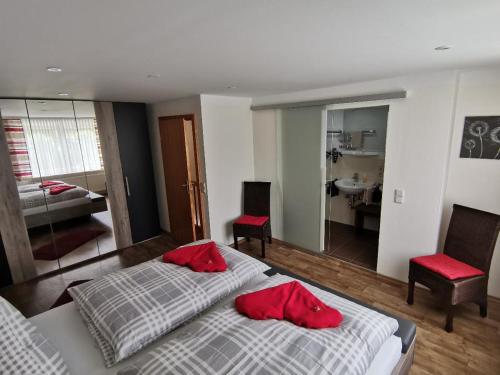 een slaapkamer met 2 bedden en 2 rode kussens bij Ferienhaus Isolde in Bodenmais