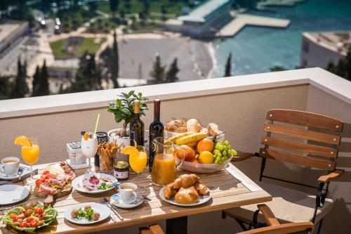 a table with breakfast foods and drinks on a balcony at Luxury Apartment Edi in Dubrovnik
