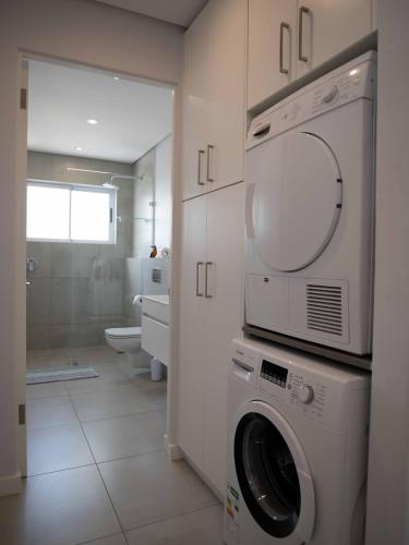 a bathroom with a washer and dryer in it at Umdloti Holiday Resort Apartments in Umdloti