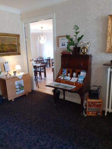 a room with a desk and a room with a dining room at Hotell S:t Olof in Falköping
