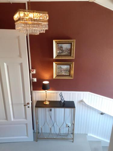 a room with a table and a chandelier at Hotell S:t Olof in Falköping