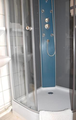 a shower with a glass door and a shower at Hotel Gai Relais in Gérardmer