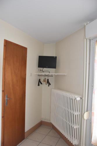 a room with a radiator and a tv on the wall at Hotel Gai Relais in Gérardmer