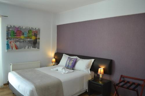 a bedroom with a bed and a painting on the wall at Rivitel Marousi Apartments in Athens