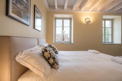 a bedroom with a white bed with two pillows at Borgo di Drugolo in Lonato del Garda
