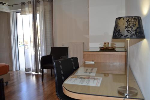 a room with a desk with a lamp and chairs at Rivitel Marousi Apartments in Athens