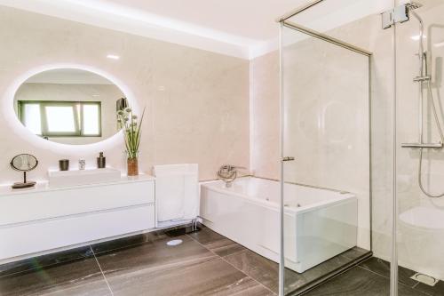 y baño con bañera, lavabo y espejo. en Villa Belmonte by LovelyStay, en Ponta do Sol