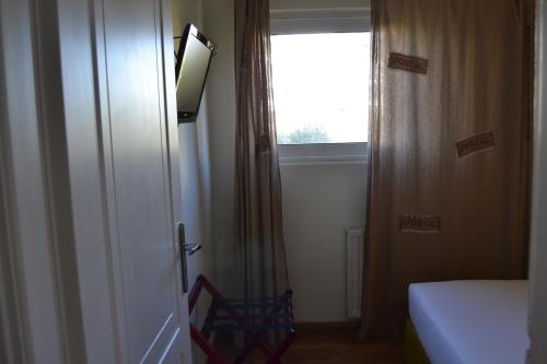 a room with a bed and a window and a chair at Rivitel Marousi Apartments in Athens