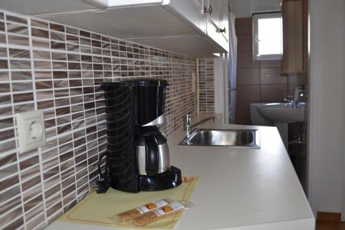 a kitchen with a coffee maker on a counter next to a sink at Rivitel Marousi Apartments in Athens