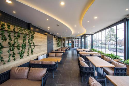 a restaurant with tables and chairs and windows at Hotel Grand in Banja Luka
