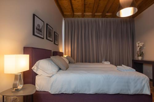 a bedroom with a large bed with white sheets at Borgo di Drugolo in Lonato del Garda