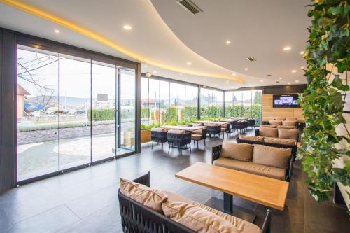 a restaurant with tables and chairs and windows at Hotel Grand in Banja Luka