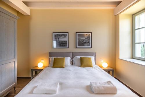 a bedroom with a large white bed with two lamps at Borgo di Drugolo in Lonato del Garda