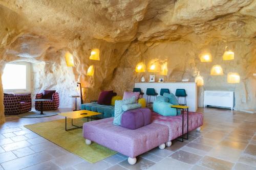 a living room with a couch and a rock wall at La Corte Dei Pastori Luxury in Matera