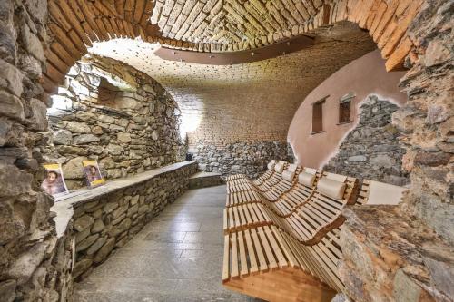 a hallway with benches in a stone wall at Hotel Alla Posta in Saint Vincent