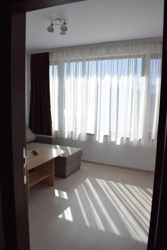 a living room with a couch and a large window at Къща за гости Шошови in Velingrad