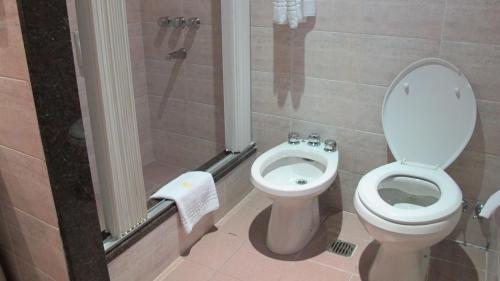a bathroom with a toilet and a shower stall at Gran Hotel Libertad in Buenos Aires