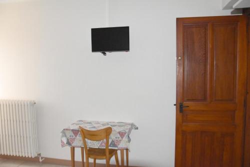 a table with two chairs and a television on a wall at Hotel Gai Relais in Gérardmer