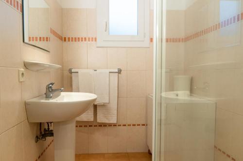 une salle de bain blanche avec un lavabo et une douche dans l'établissement Résidence Marie Diane - Laurier des Mers, à Propriano